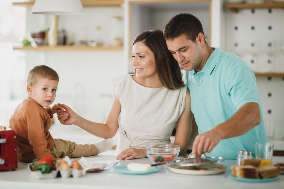 A family cooking together in a bright kitchen, a calm everyday household scene