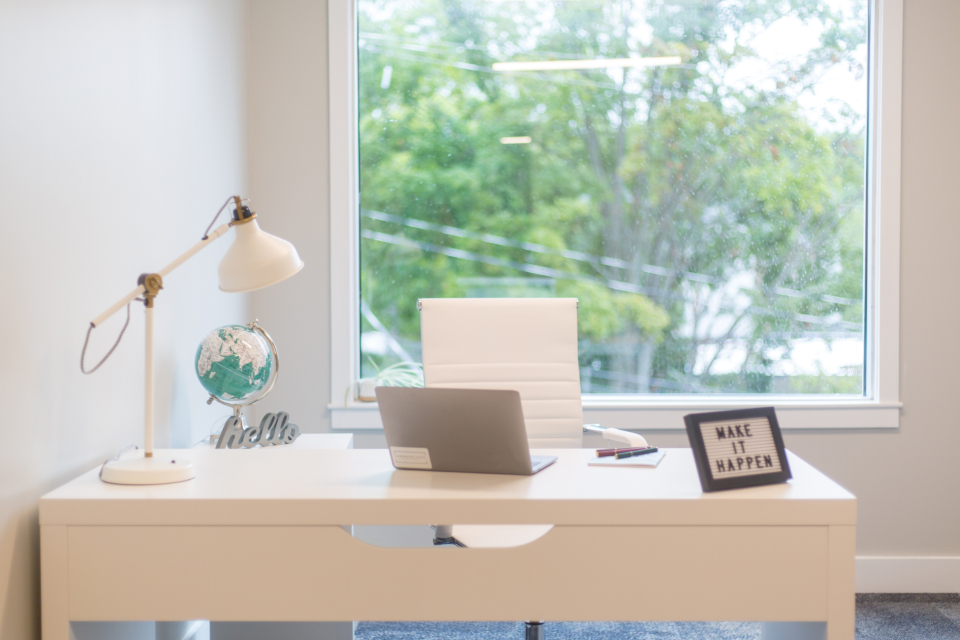 Bright home office desk with a laptop ready for an online session